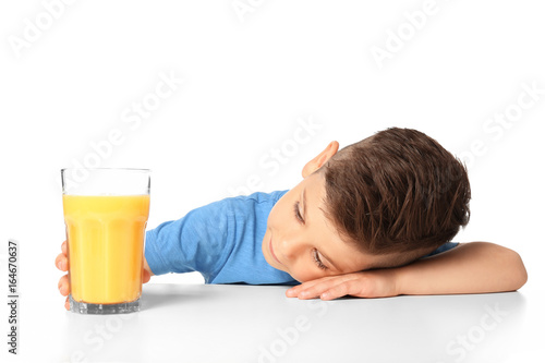 Cute little boy with glass of juice on white background