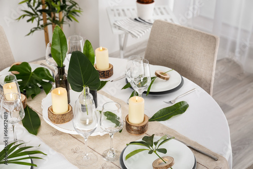 Beautiful table setting with green tropical leaves