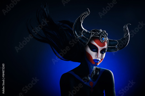 Fotografie Mystery portrait of female faun with blue eyes, body art and silver snakes on bl