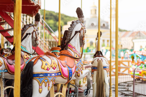 Horses on a carnival Merry Go Round. Old French carousel in a holiday park. Big roundabout at fair in amusement park.