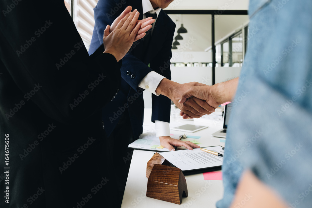 Obraz premium Estate agent shaking hands with his customer after contract signature and congratulation