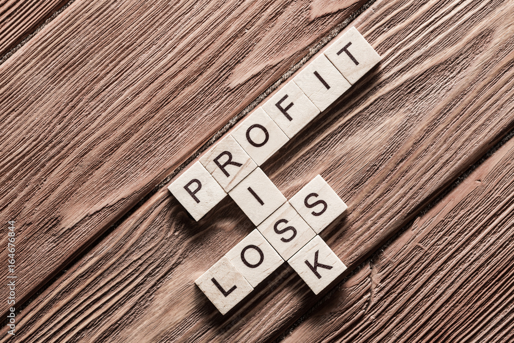 Profit loss and risk words on workplace collected of wooden cubes
