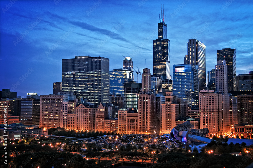 Fototapeta premium Chicago nad jeziorem panoramę miasta nocą przez park milenijny z dramatycznym pochmurnym niebem.