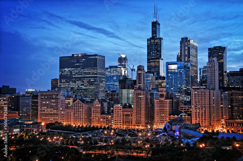 Chicago lakefront skyline cityscape at night by millenium park with a dramatic cloudy sky.