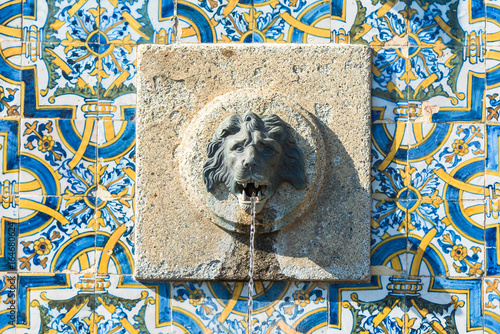 Portugal, fountain with azulejos and head of lion sculptured in the stone
