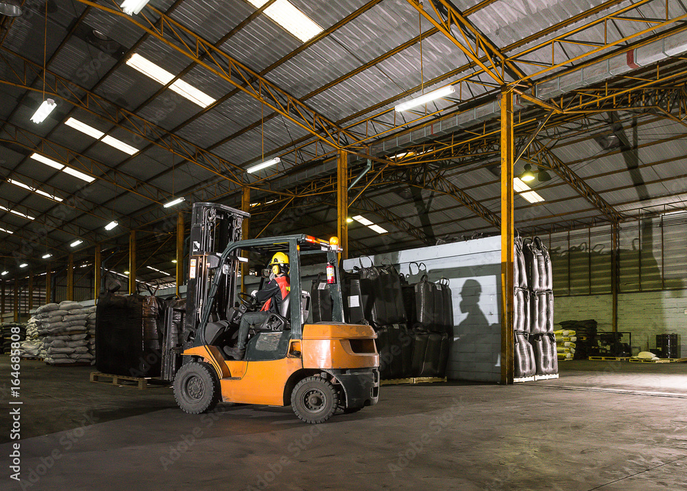 Forklift driver standing proud in manufacturing plant