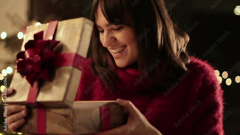 Amazed young woman looking at magical christmas gift in the box Amazed young woman looking at magical christmas gift in the box