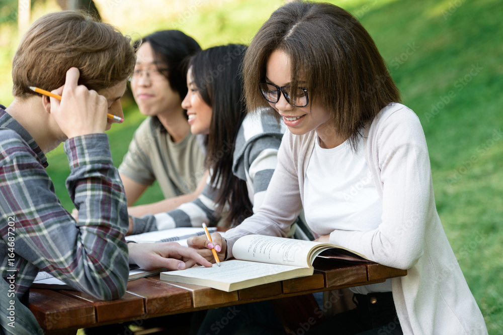 Multiethnic group of smiling young students studying Multiethnic group of smiling young students studying
