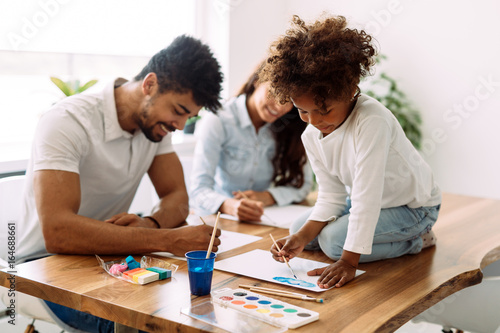 Mother and father drawing together with their child