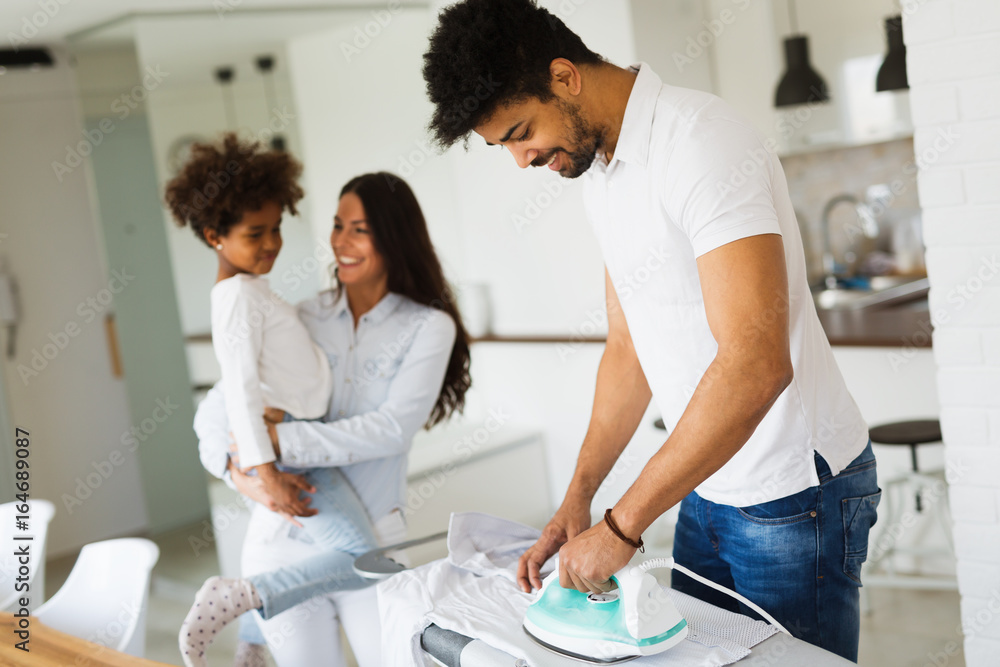Young couple at home doing hosehold chores and ironing Young couple at home doing hosehold chores and ironing