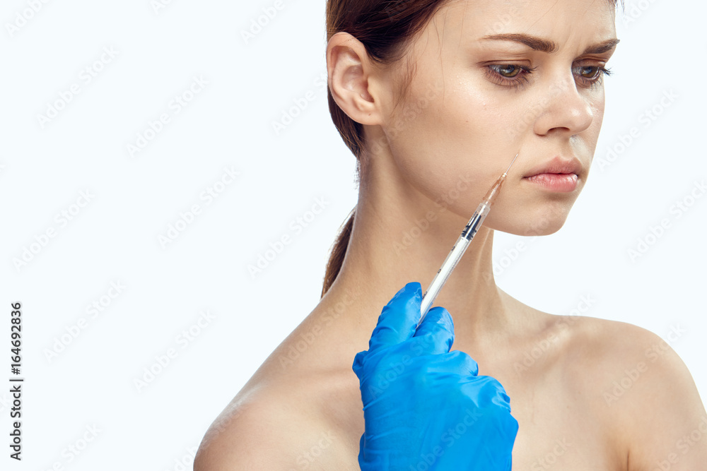 Young beautiful woman on white background isolated holding a syringe, plastic surgery Young beautiful woman on white background isolated holding a syringe, plastic surgery