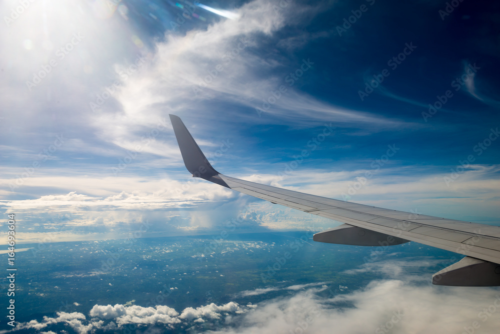 Obraz premium airplane wing with beautiful sky above the clouds