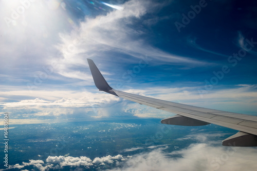 airplane wing with beautiful sky above the clouds
