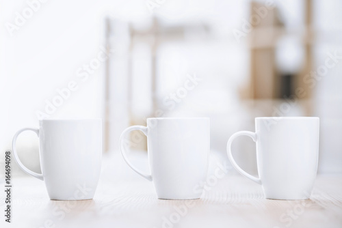 selective focus of white cups of coffee standing on table