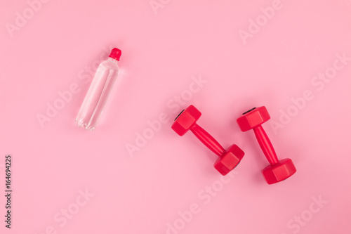 top view of red dumbbells and bottle of water isolated on pink © LIGHTFIELD STUDIOS