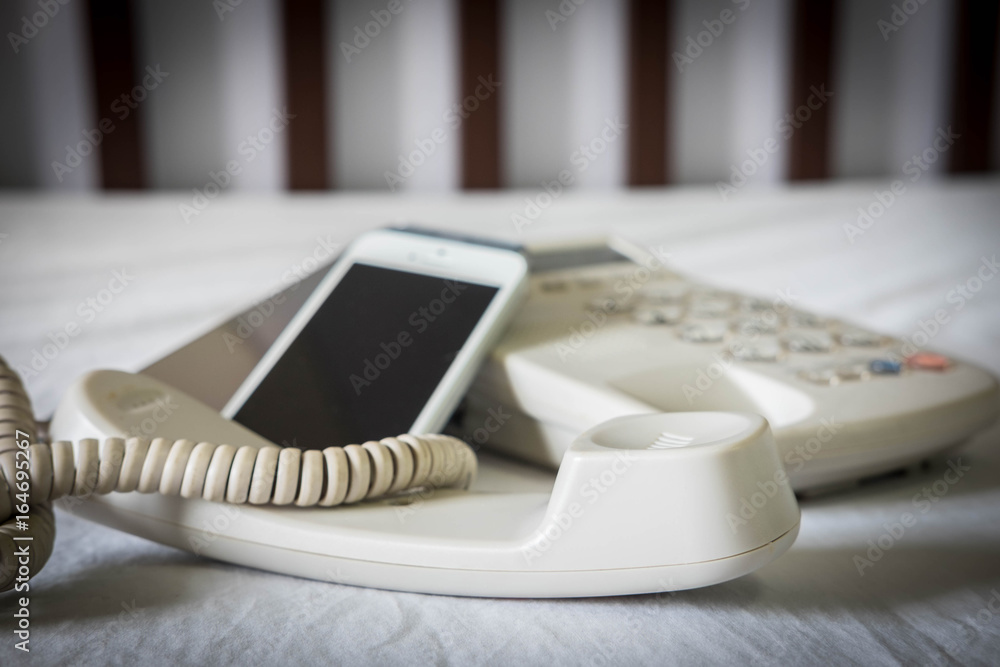 Old telephone and new mobile phone , selective focus Old telephone and new mobile phone , selective focus