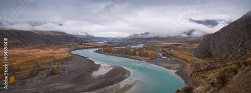 Panorama of the Altai mountains,the Katun river valley.Autumn Mountain landscape with a turquoise river, yellow trees and rain clouds. Altai, Russia.