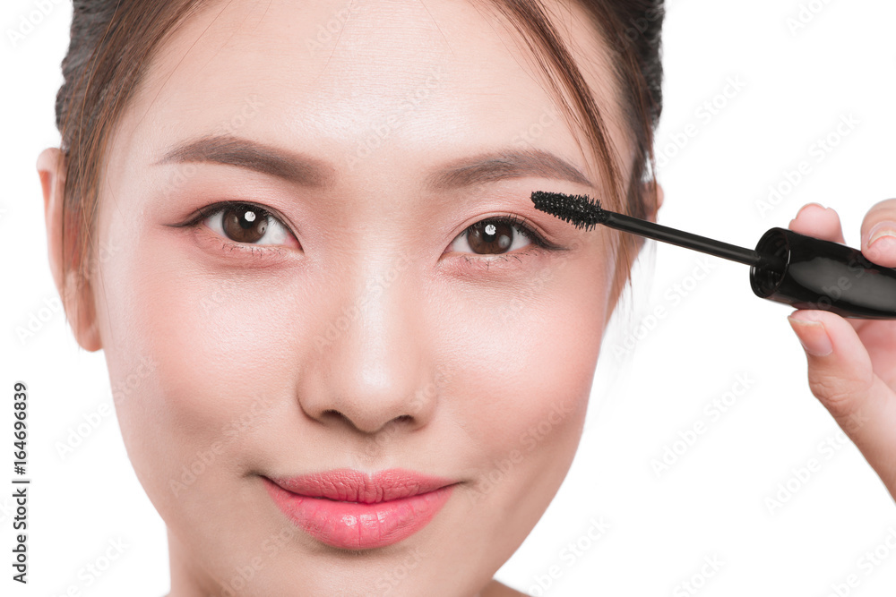 Portrait of a girl with a make-up brush for lash in hands isolated on white