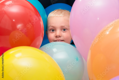 Portrait of happy little boy with colored balloons.