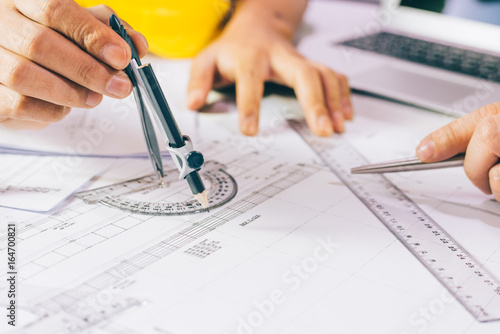Hands of Engineer working Design on blueprint,Construction concept. Engineering tools,Architectural project,blueprint rolls and divider compass. Construction concept,Copy space,business industrial