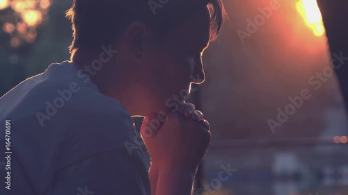 Sad depressive woman sitting on park bench in summer sunset, back lit adult lonely female person crying in despair