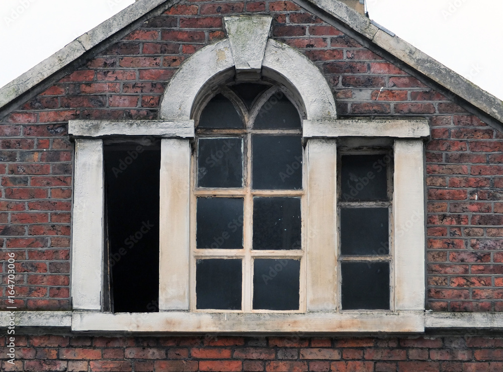 broken windows in an abandoned derelict old commerical building with brickwork stone frame and roof, Halifax england broken windows in an abandoned derelict old commerical building with brickwork stone frame and roof, Halifax england