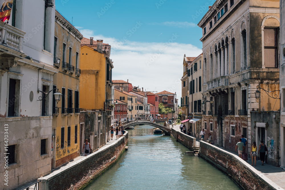 View on a venetian canal with ancient buildings and bridge in Venice