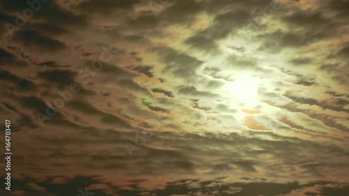 Beautiful timelapse shot of the sun travelling behind a cinematically cloudy sky. photo