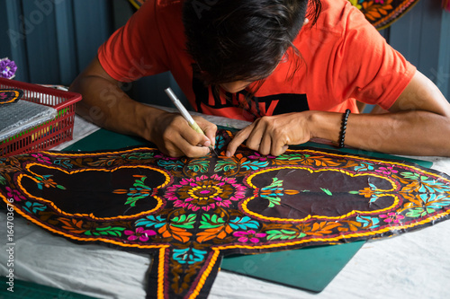 Unidentified man is making the traditional moon kite or locally known as 