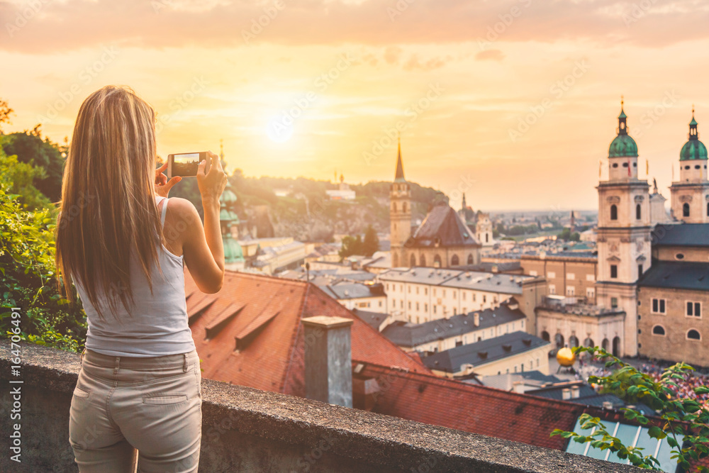 Naklejka premium Turysta robi zdjęcie pięknego zachodu słońca w Salzburgu w Austrii