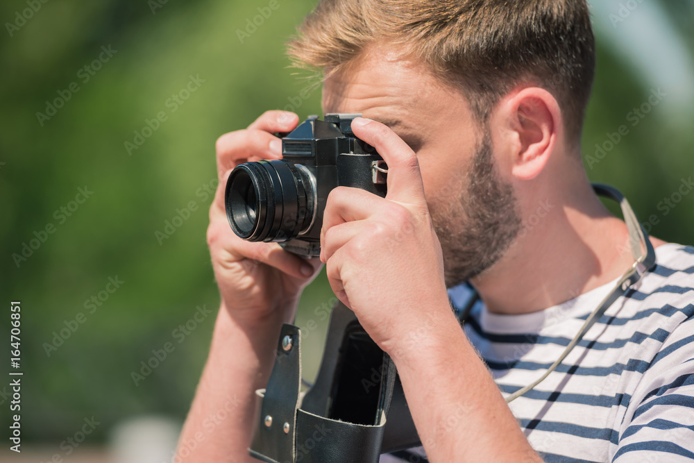 Obraz premium bearded male photographer holding camera and taking photos