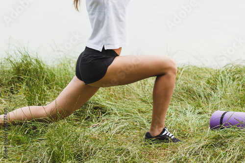 Sporty attractive woman on the lakes coast makes sport exercise