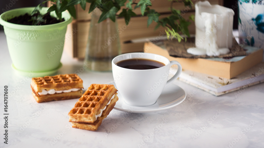 Fototapeta premium Cup of coffee and Belgian waffles with cream for breakfast