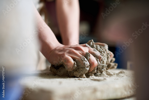 Artist kneads clay for work