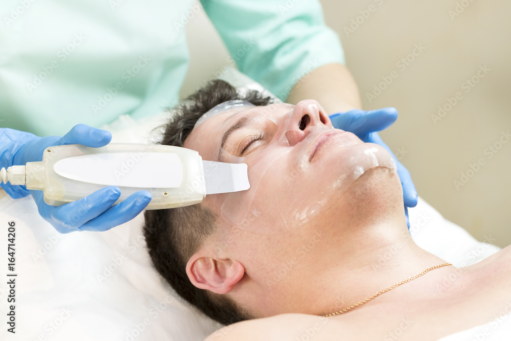 Man in the mask cosmetic procedure in spa salon Man in the mask cosmetic procedure in spa salon