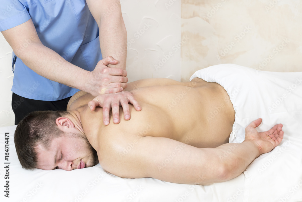 Man doing sports massage at the massage parlor Man doing sports massage at the massage parlor