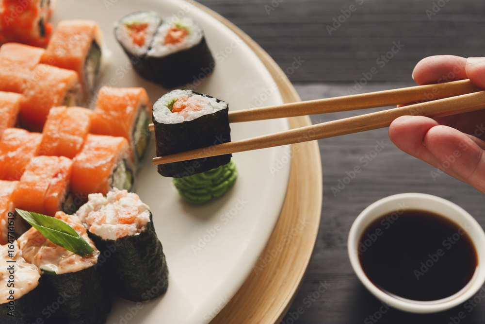 Eating sushi and rolls in japanese restaurant Eating sushi and rolls in japanese restaurant