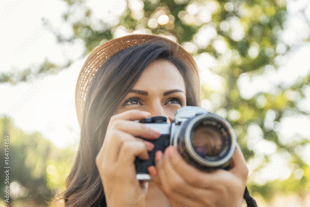 Young woman using a camera to take photo. Young woman using a camera to take photo.