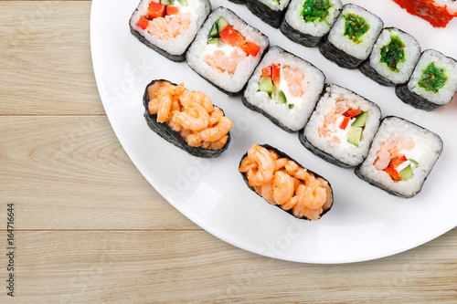 Colorful set of sushi and rolls top view on wood, closeup