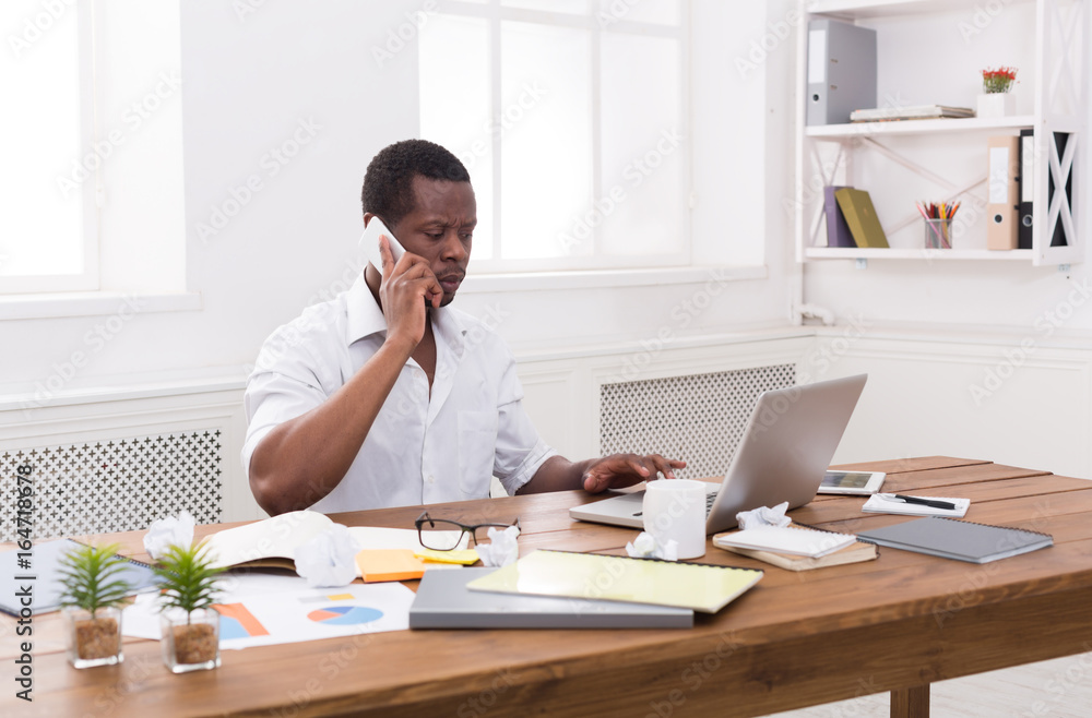 Young black businessman call mobile phone in modern white office Young black businessman call mobile phone in modern white office