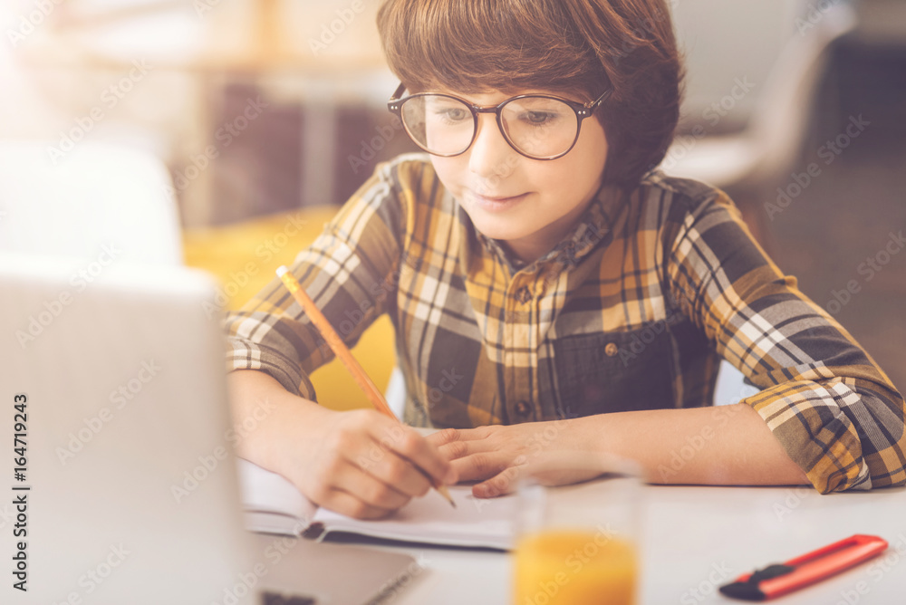 Cute clever boy doing his school assignment Cute clever boy doing his school assignment