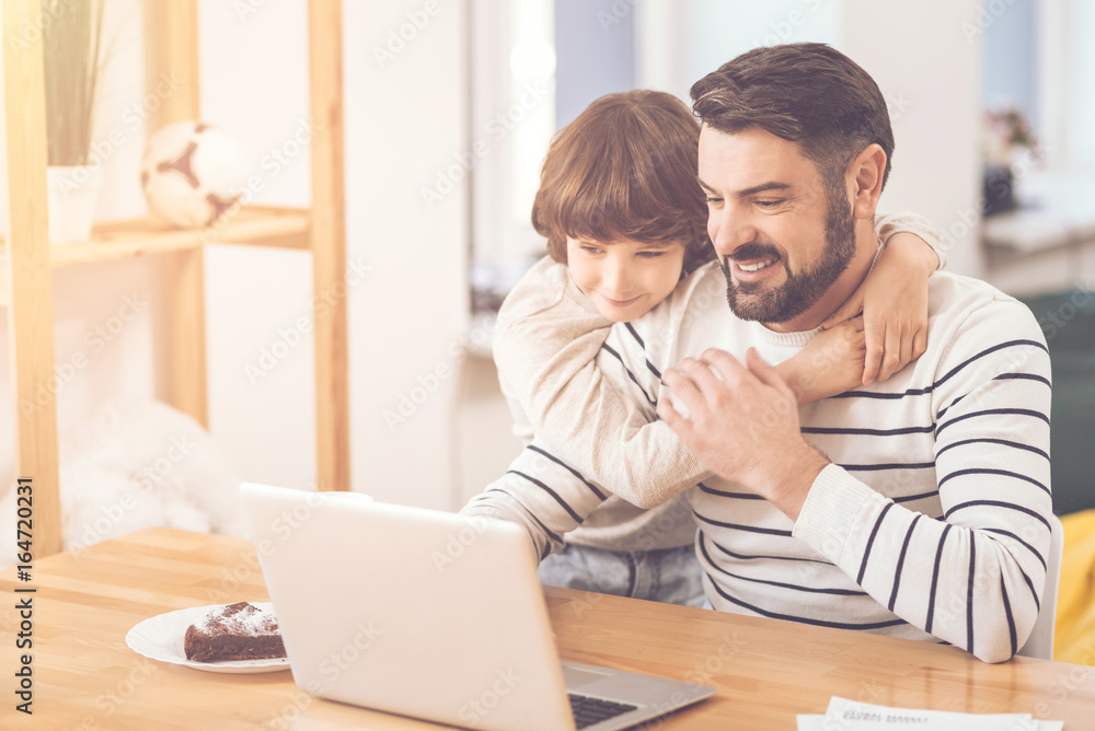 Cute delighted boy hugging his father Cute delighted boy hugging his father