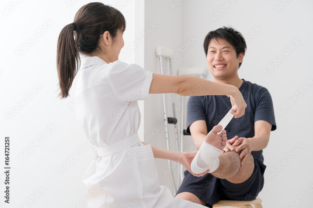 Obraz premium 足に包帯を巻く看護師、患者
