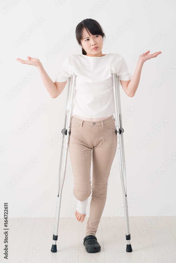 松葉杖を使う女性、足、怪我、包帯