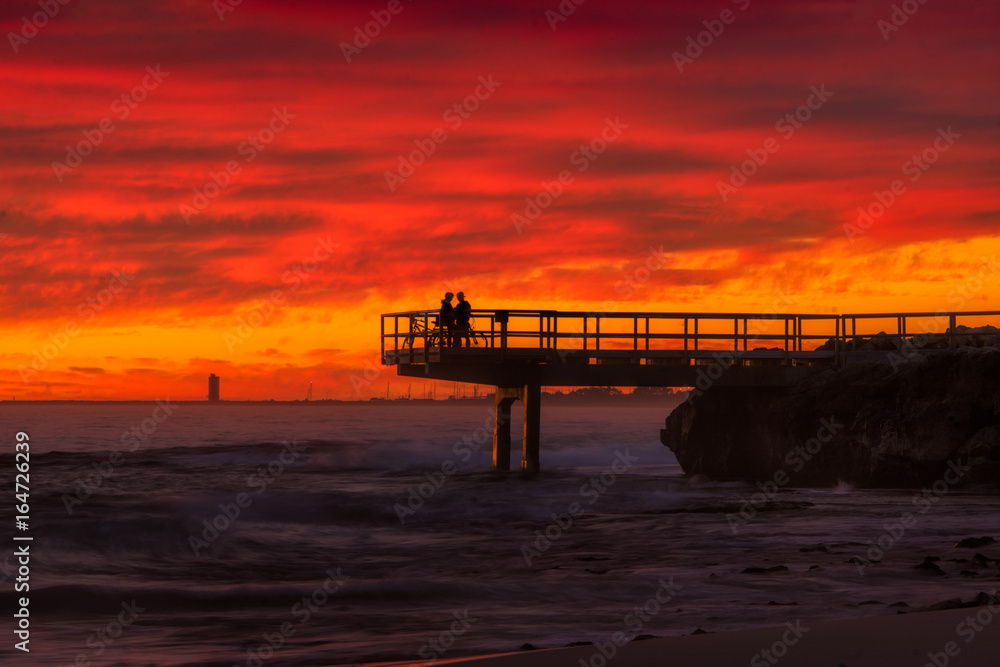 Couple cuddling on a jetty at sunset in North Beach, Western Australia