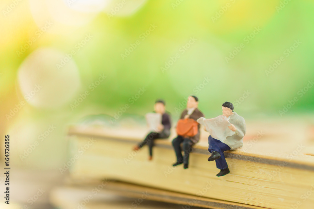 Miniature people sitting on the book using as background education or business concept Miniature people sitting on the book using as background education or business concept