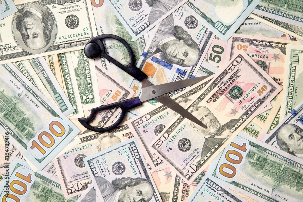 Symbol of the sequester of the budget on the background of the American currency Symbol of the sequester of the budget on the background of the American currency