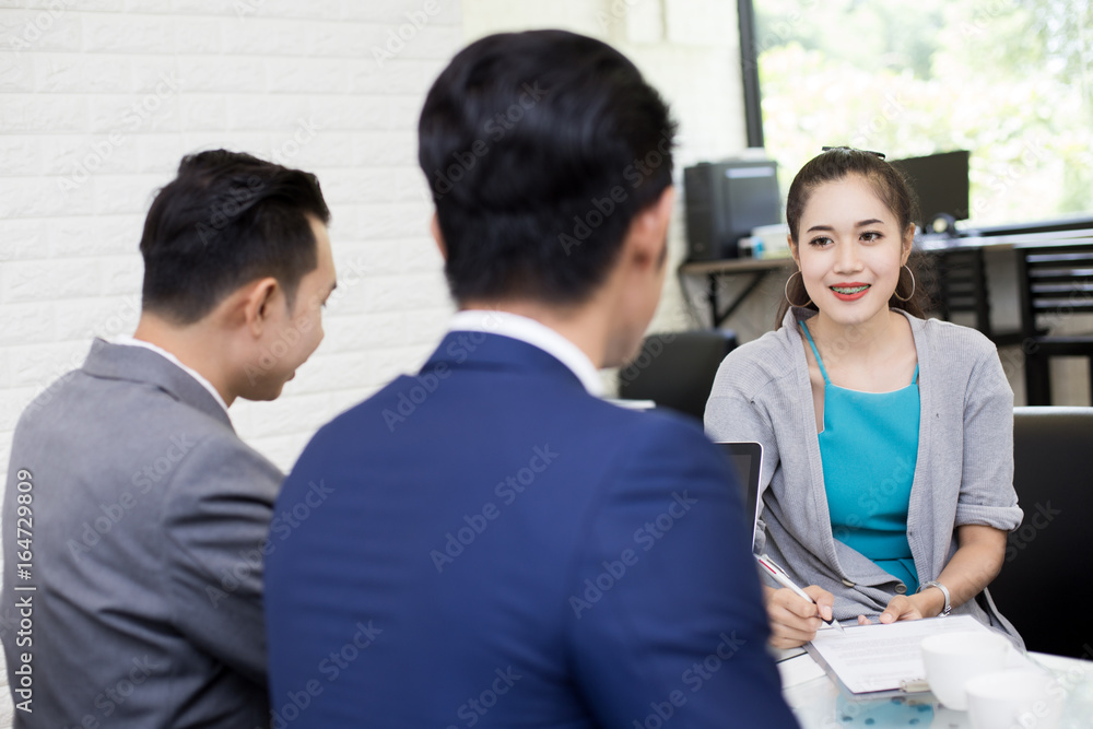 Asian woman try to writing detail of insurance paper to customer at cafe. Woman in presentation concept. 20-30 years old. Asian woman try to writing detail of insurance paper to customer at cafe. Woman in presentation concept. 20-30 years old.