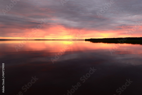 Sunset over the surface of the lake water