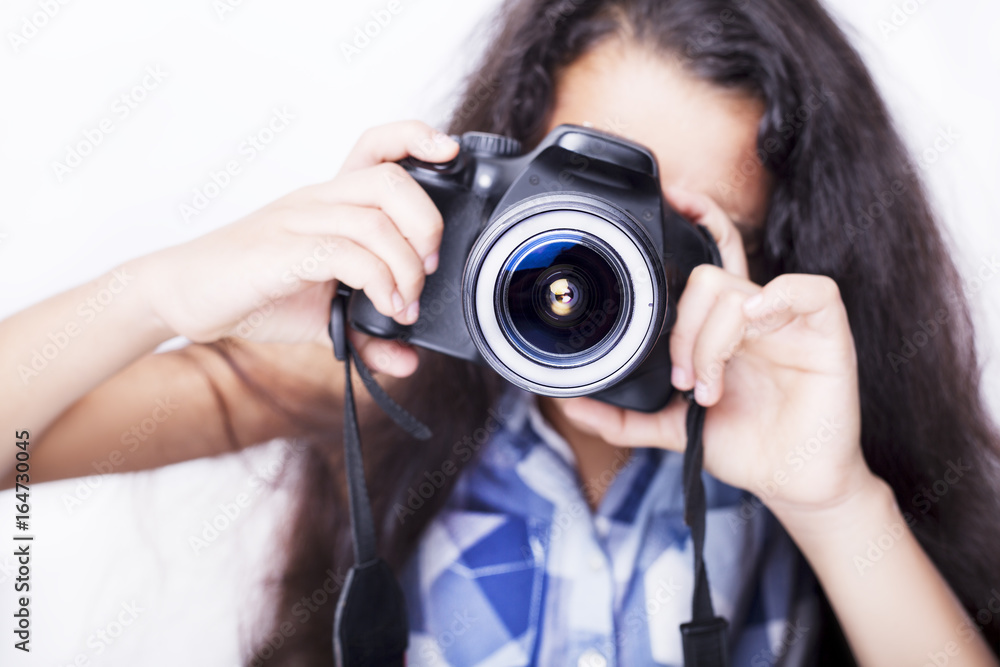 Cute brunette little girl holding an photo camera, isolated on white background Cute brunette little girl holding an photo camera, isolated on white background